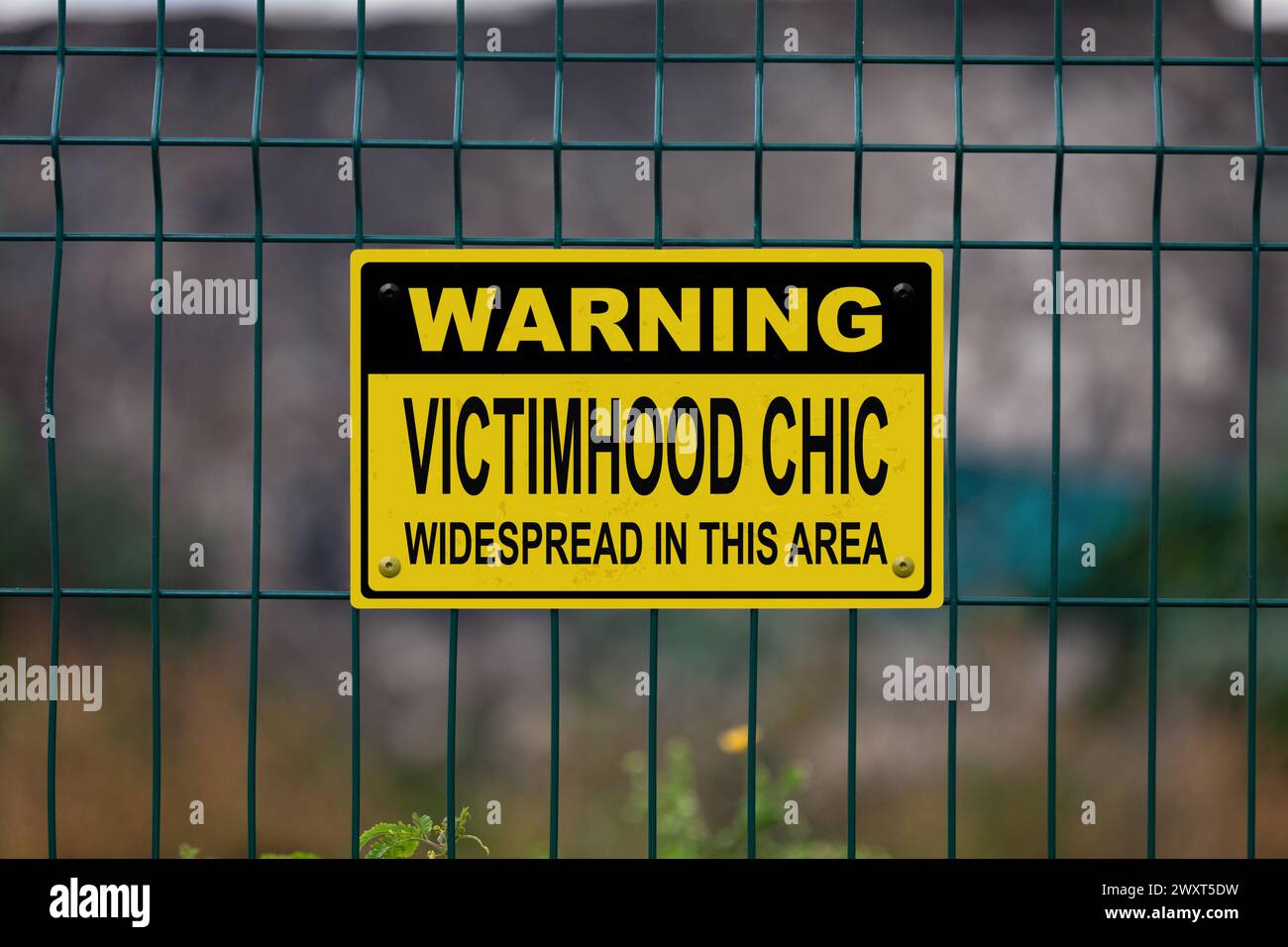 Panneau d'avertissement sur une clôture indiquant dans « avertissement, chic de la victime répandue dans cette zone ». Banque D'Images