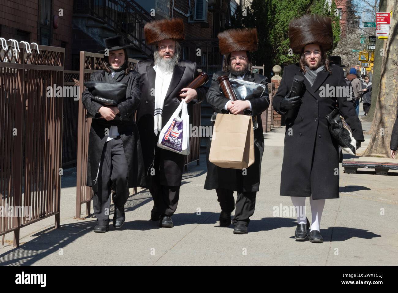 $ des hommes juifs orthodoxes, 3 en chapeaux de fourrure shtreimel, rentrent à pied de la synagogue sur Bedford Ave à Brooklyn, New York. Banque D'Images