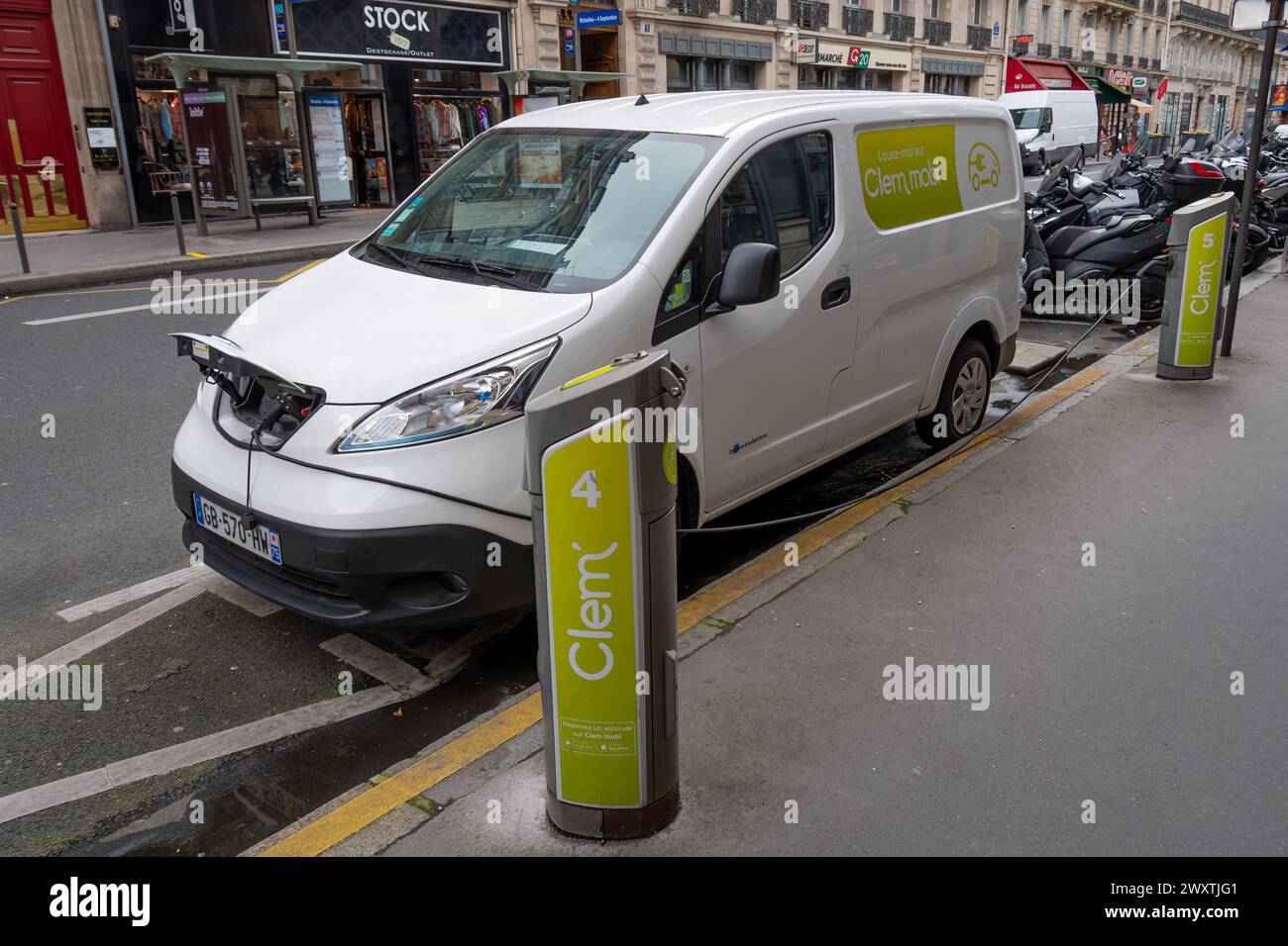 Borne de recharge de la société française Clem' chargeant un véhicule électrique utilitaire d'autopartage dans une rue de Paris, France Banque D'Images
