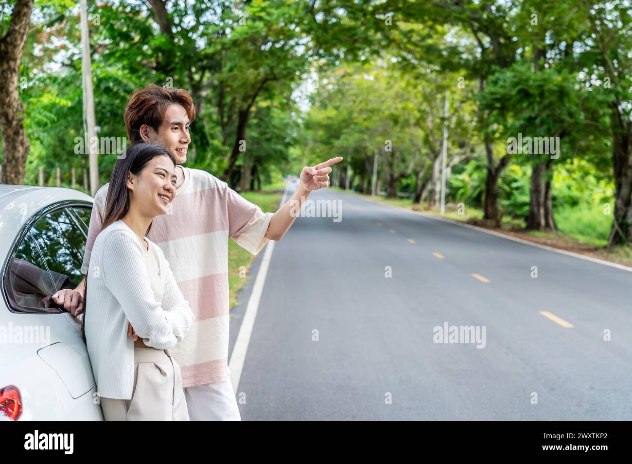 Un couple dans une voiture, observant quelque chose sur la route Banque D'Images