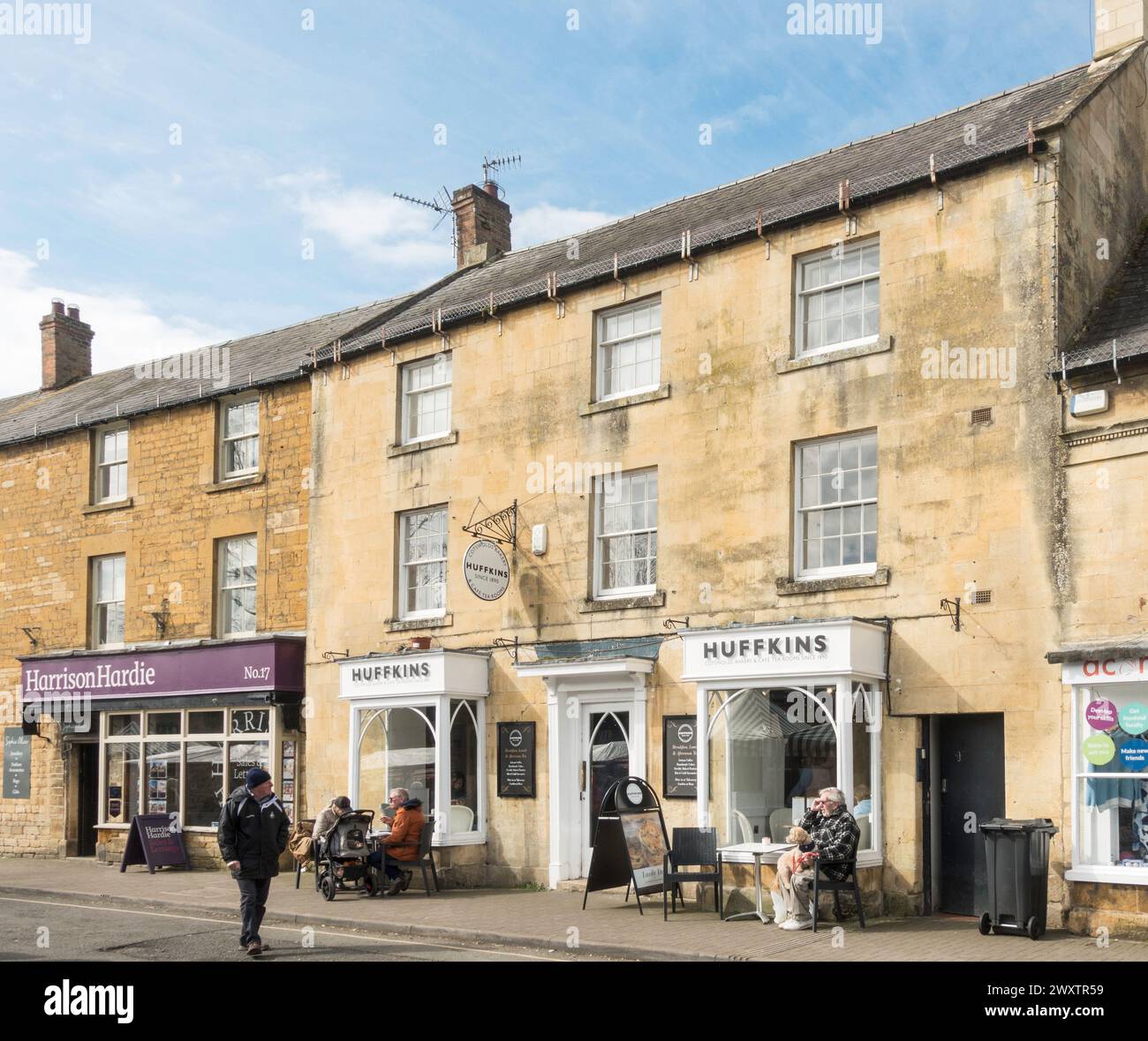 Personnes assises devant les salons de thé Huffkins à Moreton à Marsh, Gloucestershire, Angleterre, Royaume-Uni Banque D'Images