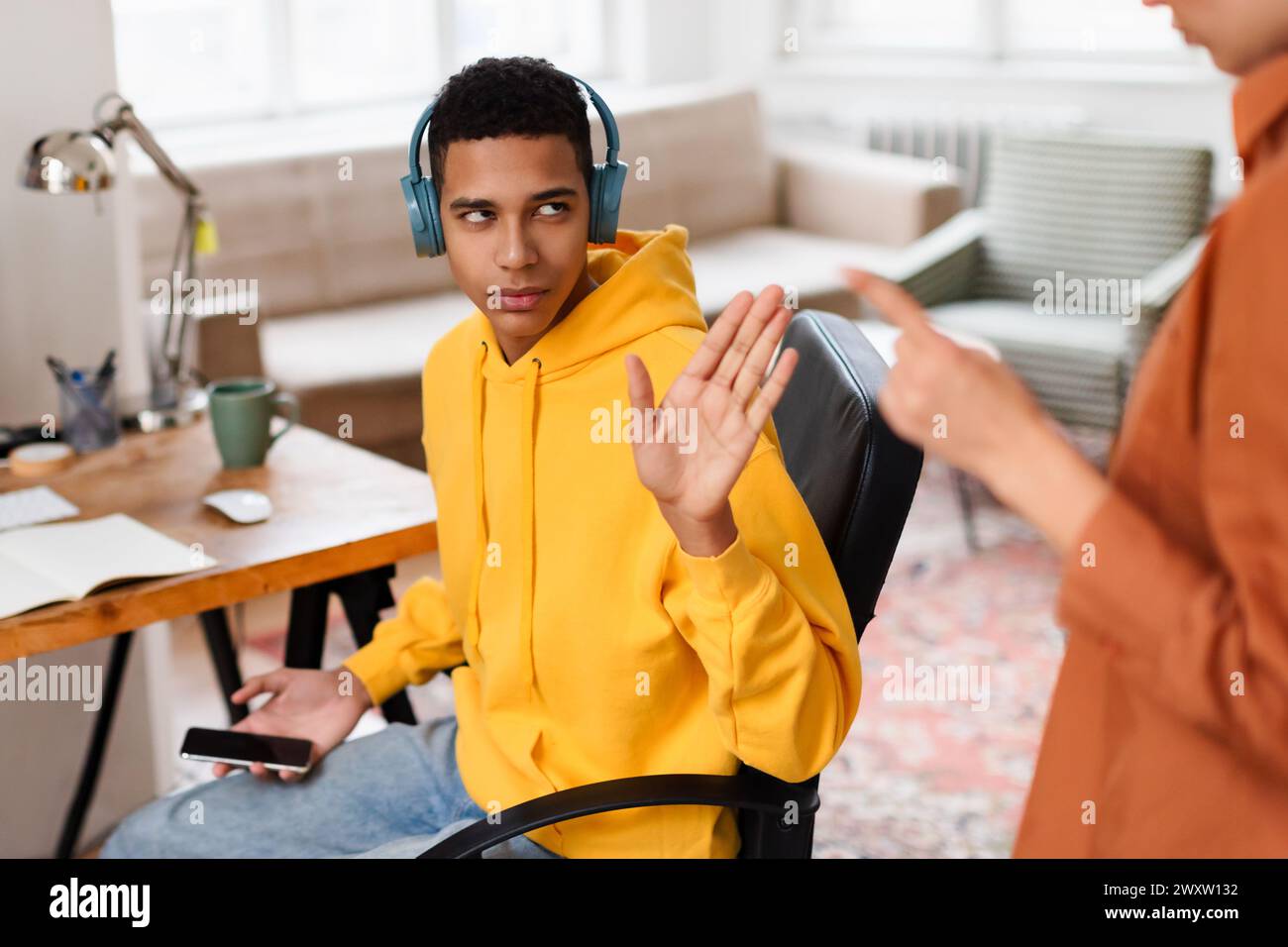 Homme avec des écouteurs faisant des gestes alors qu'au bureau Banque D'Images