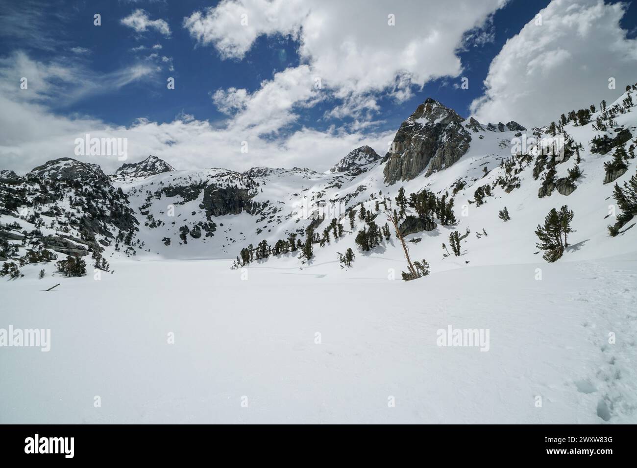 Pacific Crest Trail. Une chaîne de montagnes enneigée avec un ciel bleu clair. Le ciel est parsemé de nuages Banque D'Images