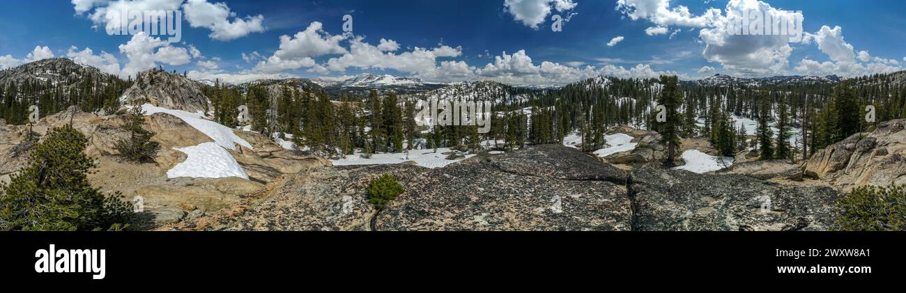 Pacific Crest Trail. Une vue panoramique sur une chaîne de montagnes enneigée avec des arbres et de la neige. Le ciel est bleu et les nuages sont dispersés Banque D'Images