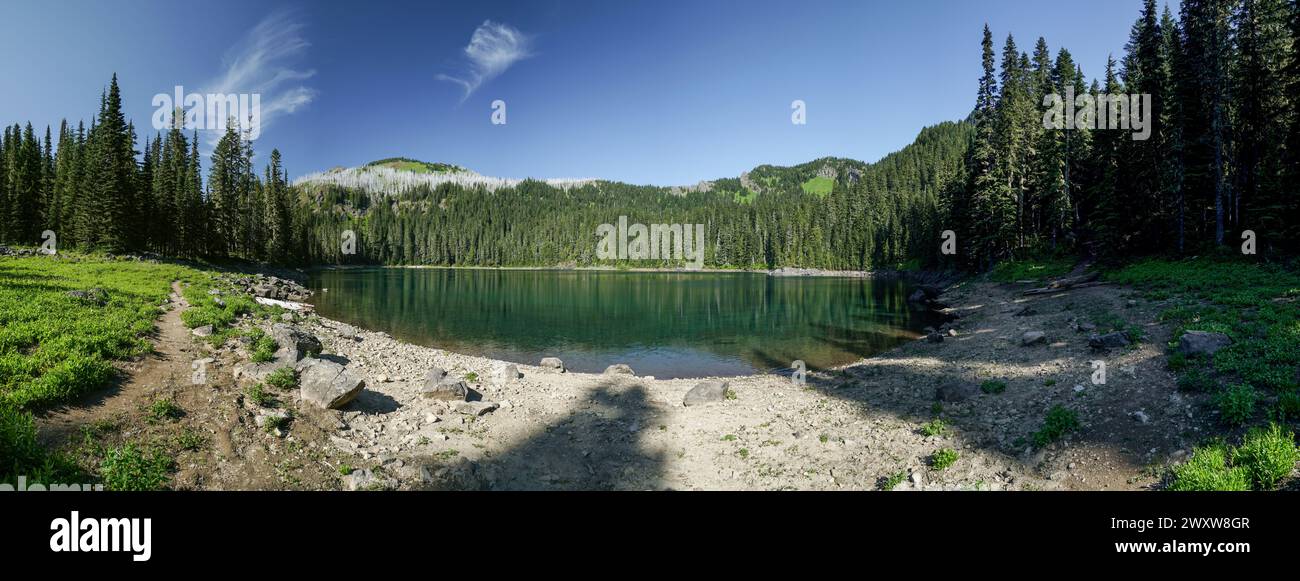 Pacific Crest Trail. Un beau lac entouré d'arbres et de rochers. Le ciel est clair et bleu, et le soleil brille. La scène est paisible Banque D'Images