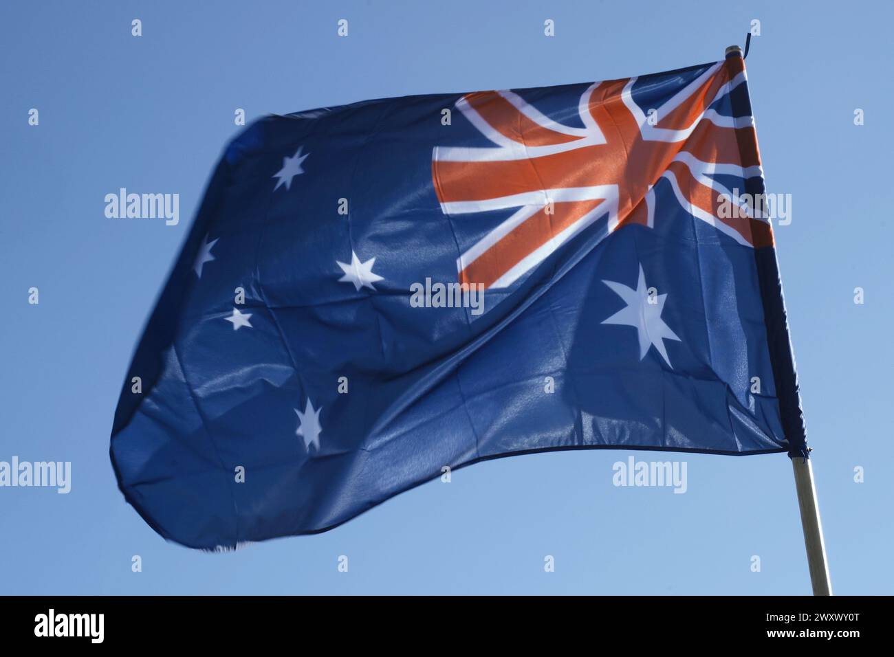 Le drapeau national australien flotte dans le vent, mettant en valeur son emblématique motif Union Jack et étoile sous le ciel lumineux. Banque D'Images