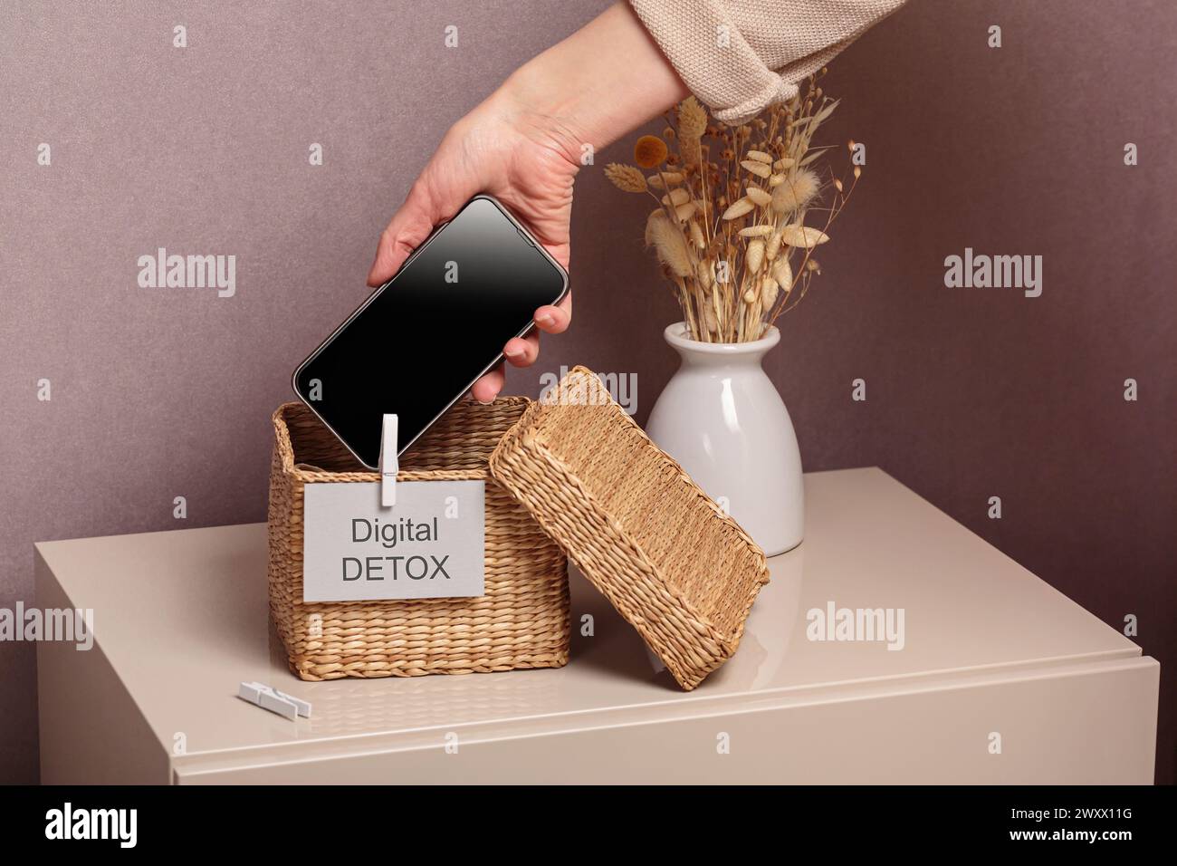 Femme mettant le téléphone dans une boîte avec différents gadgets à la maison Banque D'Images