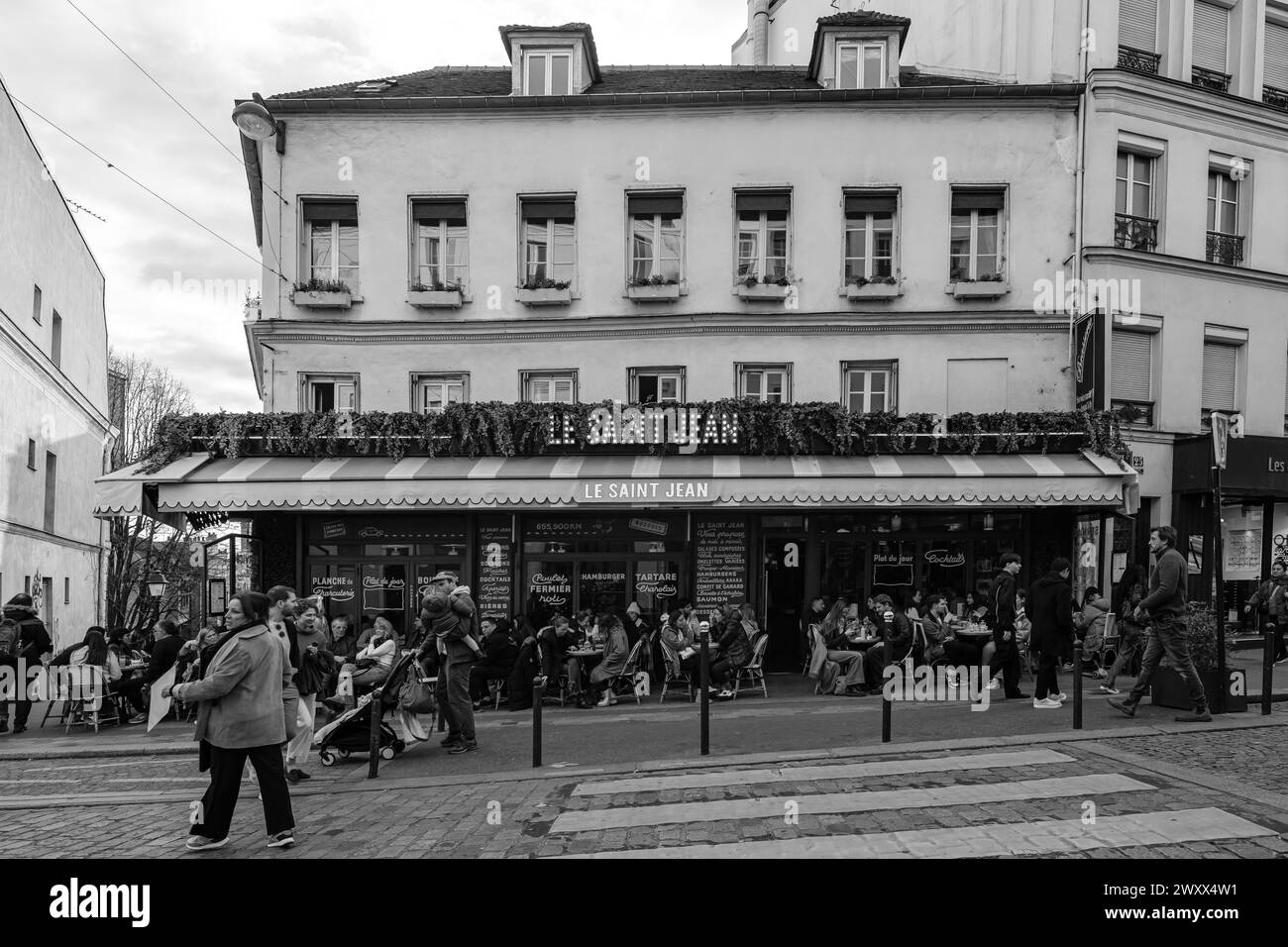 Paris, France - 17 février 2024 : vue de personnes assises à l'extérieur et dégustant un dîner et un verre dans un café restaurant bistro à Paris France Banque D'Images