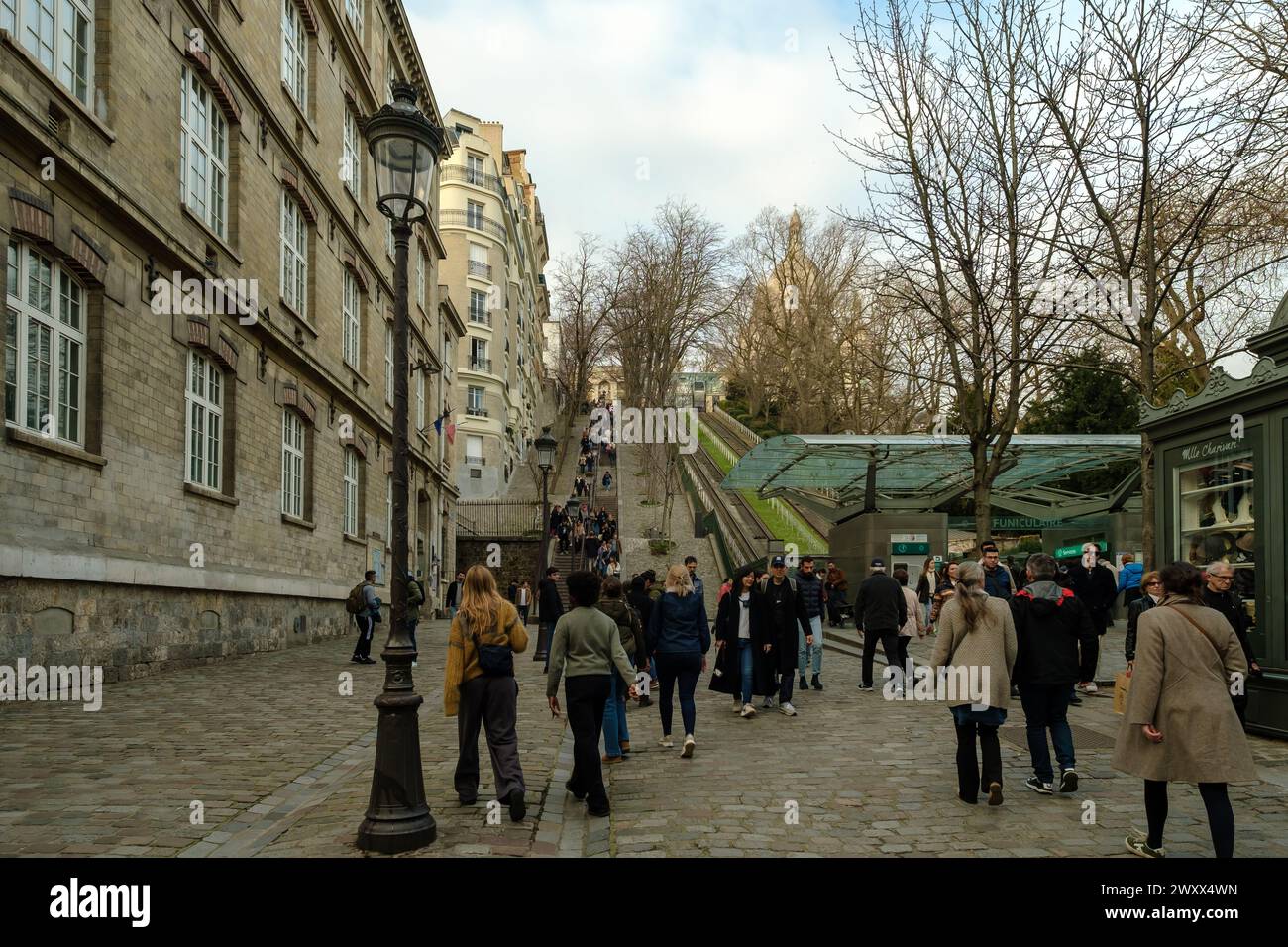 Paris, France - 17 février 2024 : vue panoramique des touristes qui montent et descendent les escaliers pittoresques à côté d'un funiculaire de Montmartre Paris Banque D'Images