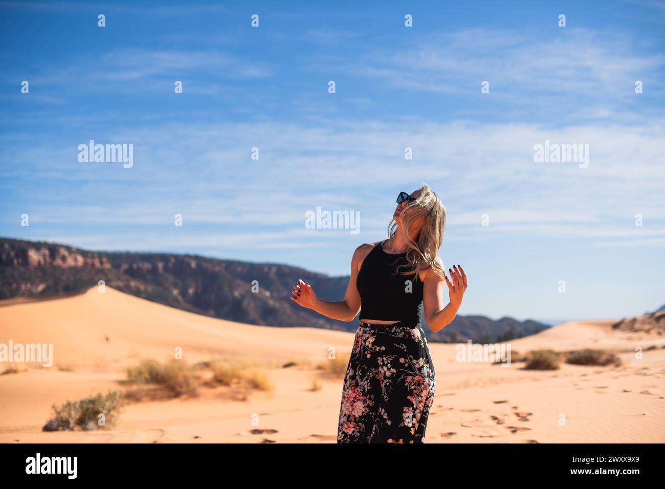 Femme marchant sur une dune de sable dans le désert à Coral Pink Sand Dunes State Park, Utah Banque D'Images