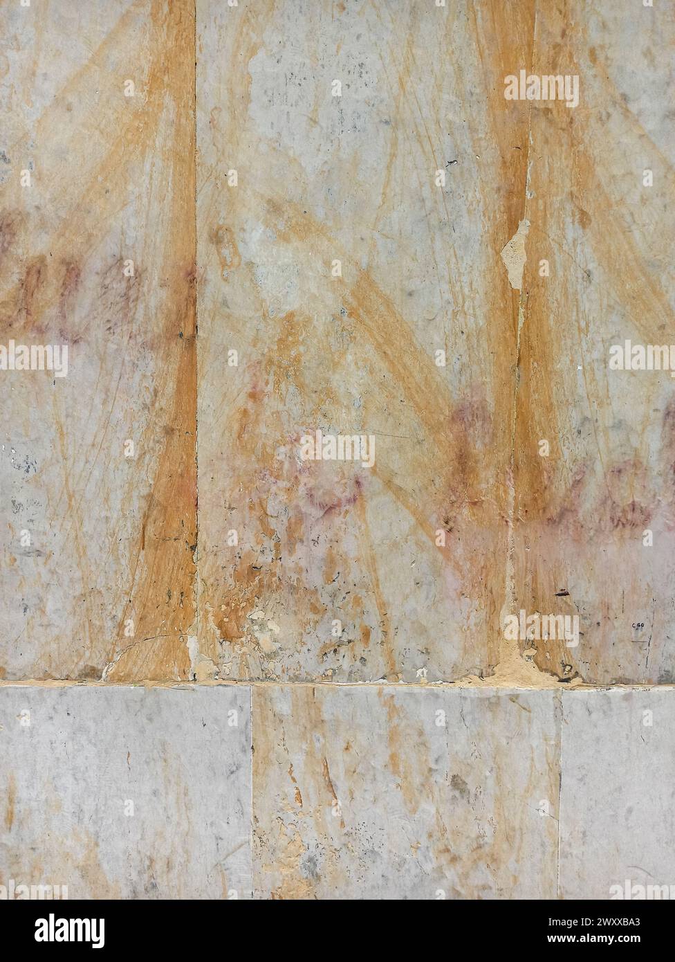 Texture de marbre jaune avec des veines sur le mur d'une façade extérieure vieillie dans une ville Banque D'Images