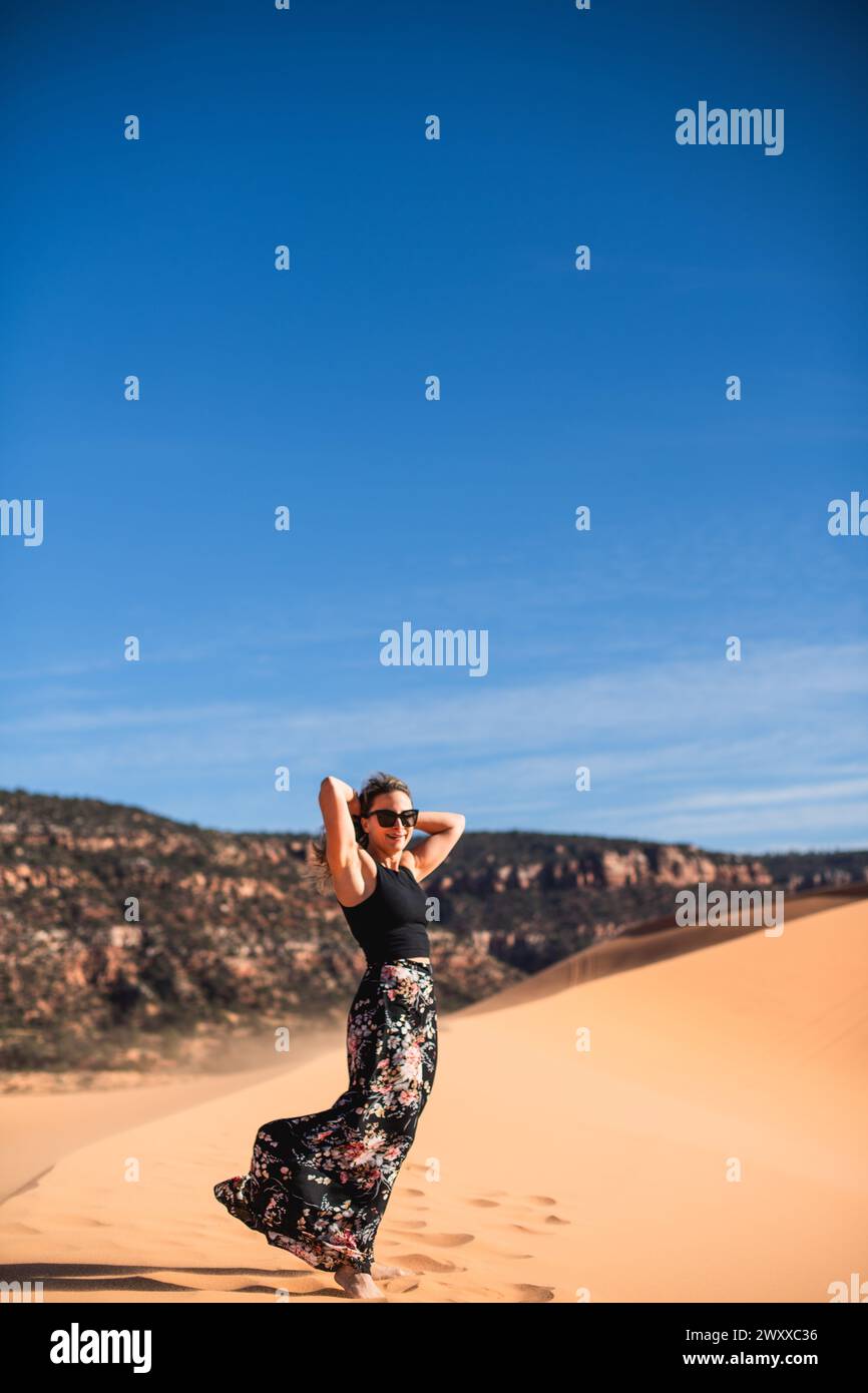 Femme marchant sur une dune de sable dans le désert à Coral Pink Sand Dunes State Park, Utah Banque D'Images