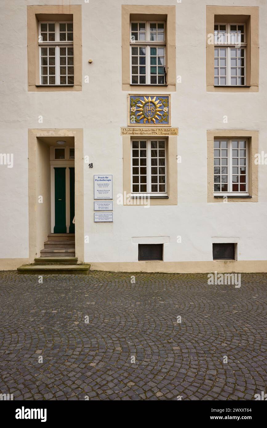 Façade d'un bâtiment historique avec fenêtres blanches, porte et armoiries familiales colorées dans la vieille ville de Warendorf, quartier de Warendorf, Nord Banque D'Images