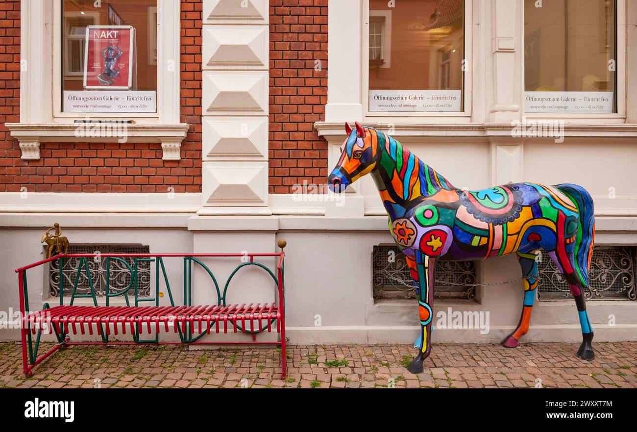 Sculpture de cheval colorée dans le style du pop art et un banc rouge dans la ville des chevaux Warendorf, quartier de Warendorf, Rhénanie du Nord-Westphalie Banque D'Images