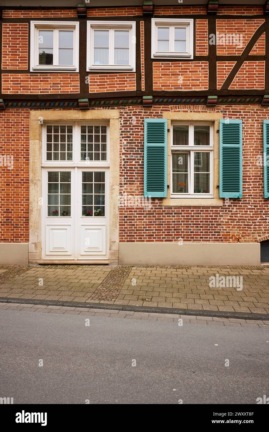 Porte d'entrée blanche et fenêtres avec volets bleu-vert sur une maison en brique à Warendorf, quartier de Warendorf, Rhénanie du Nord-Westphalie, Allemagne Banque D'Images