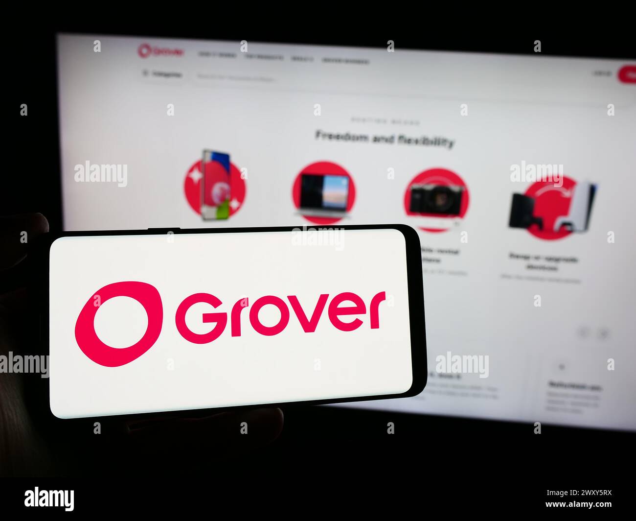 Personne tenant un smartphone avec le logo de la société allemande de location d'électronique grand public Grover en face du site Web. Concentrez-vous sur l'affichage du téléphone. Banque D'Images