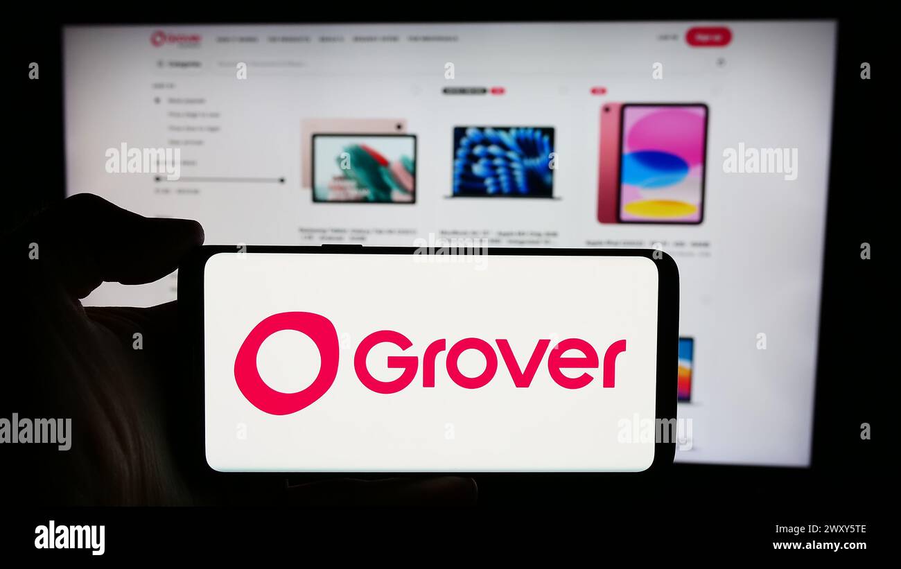 Personne tenant le téléphone portable avec le logo de la société allemande de location d'électronique grand public Grover devant la page Web de l'entreprise. Concentrez-vous sur l'affichage du téléphone. Banque D'Images