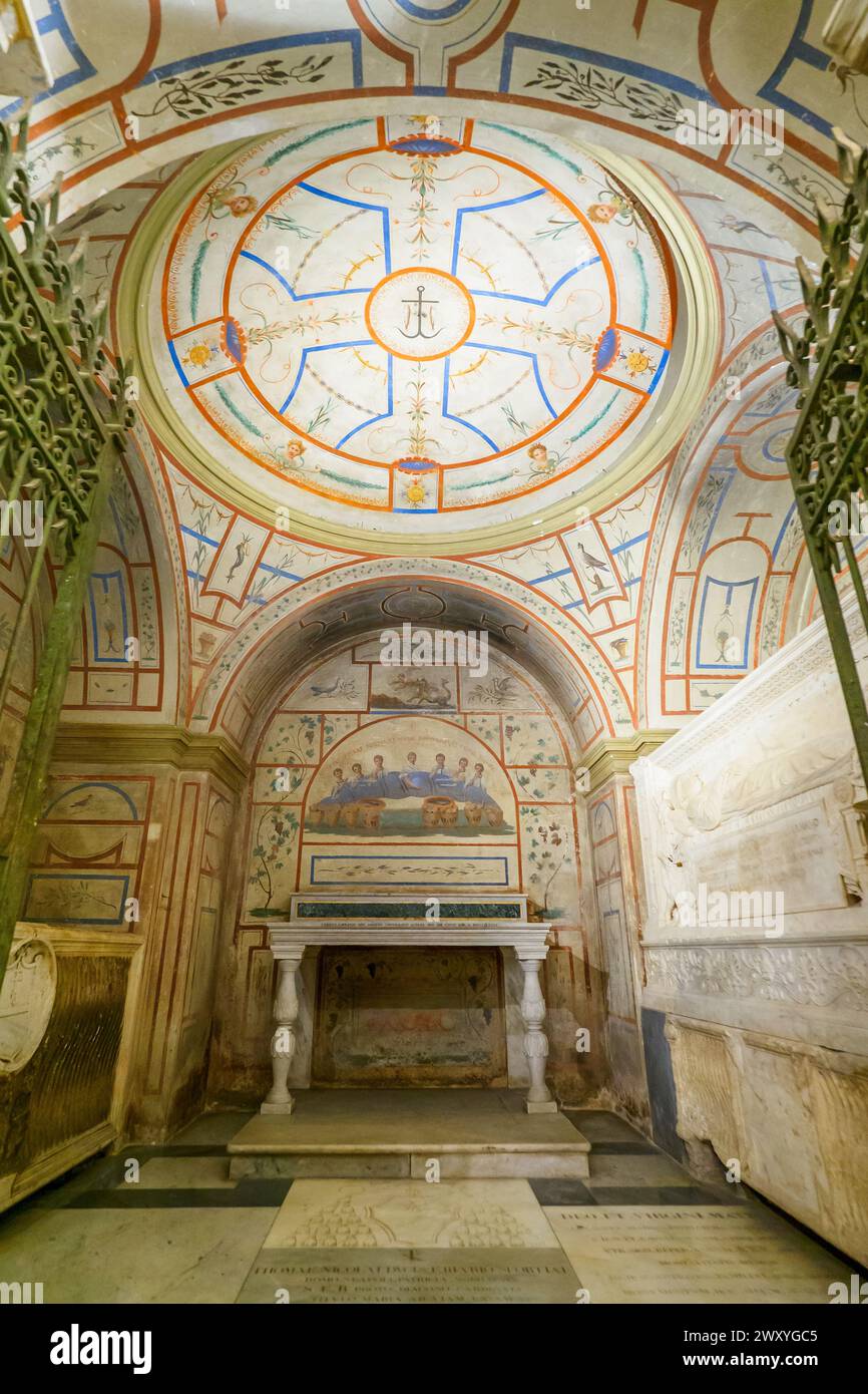 La vaste crypte sous le maître-autel, construite par Luigi Carimini en 1869-71 rassemblant, en plus des restes des apôtres titulaires Philippe et Jacques, les reliques de divers autres martyrs qui ont été révélées au cours de ces fouilles, et les tombeaux de deux de Riario qui avaient autrefois le droit d'être enterrés au presbytère. Les décorations de tempera du déambulatoire sont inspirées de celles des catacombes de San Callisto et Domitilla. - Basilica dei Santi XII Apostoli - Rome Italie Banque D'Images