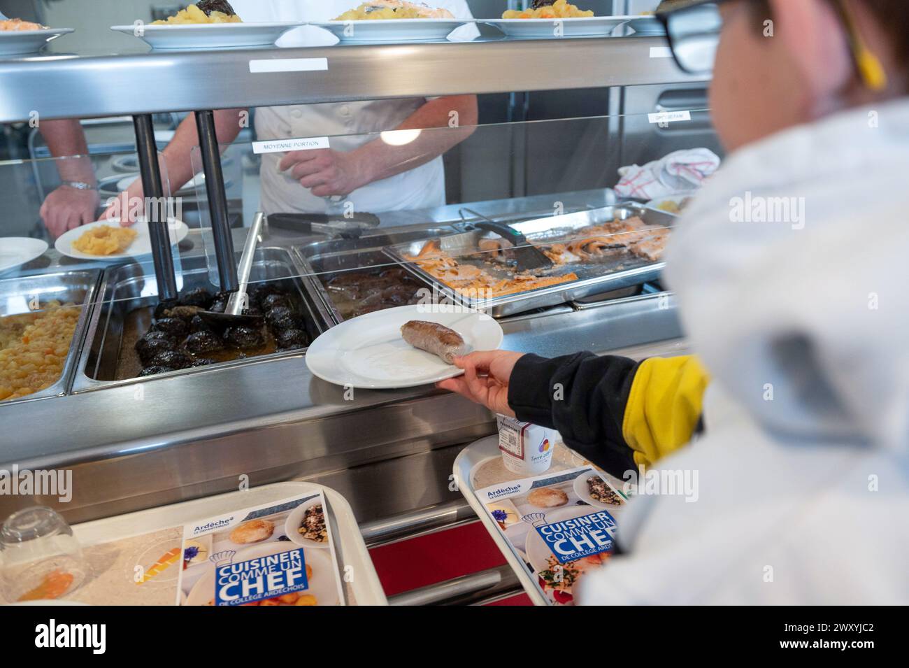 Déjeuner à la cantine du collège « collège de la Voulte » (sud-est de la France) : étudiant portant un plateau avec repas Banque D'Images