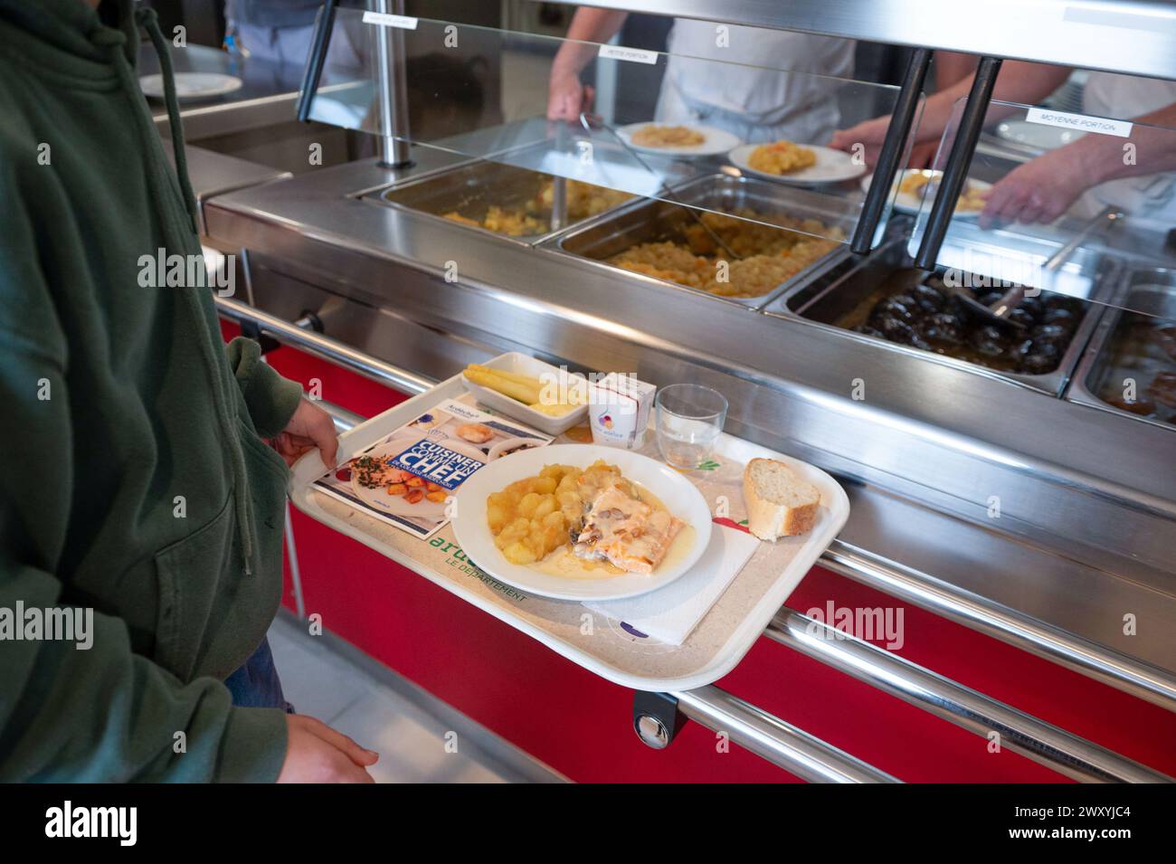 Déjeuner à la cantine du collège « collège de la Voulte » (sud-est de la France) : étudiant portant un plateau avec repas Banque D'Images