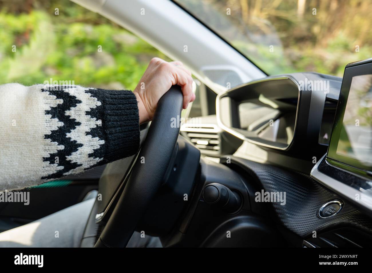 Gros plan de la main d'une personne tenant le volant à l'intérieur d'une voiture moderne Banque D'Images