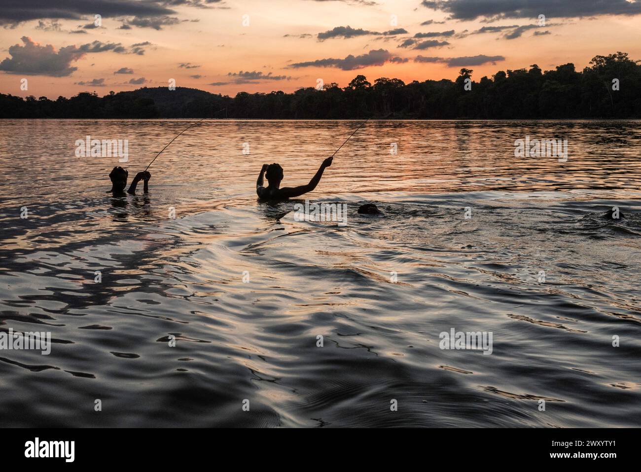 Papaitchon, rivière Maroni (ou Marowijne), Guyane française : les enfants s'amusent, jouent et pêchent au coucher du soleil Banque D'Images