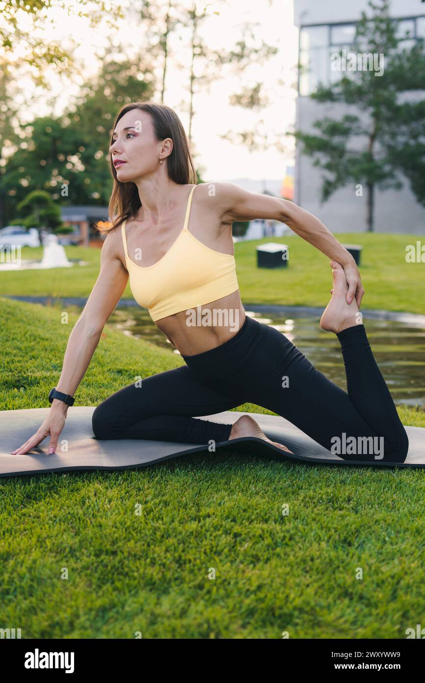 Vue latérale de la jeune femme pratiquant le yoga à l'extérieur.Yoga et concept Relax. Belle femme pratiquant le yoga Banque D'Images