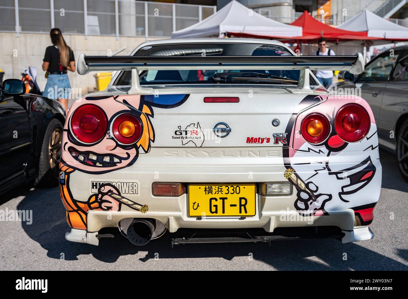 Vue arrière d'une Nissan Skyline GT R34 de dixième génération avec quelques vinyles de dessins Doraemon lors d'une rencontre de voitures de sport japonaises. Banque D'Images