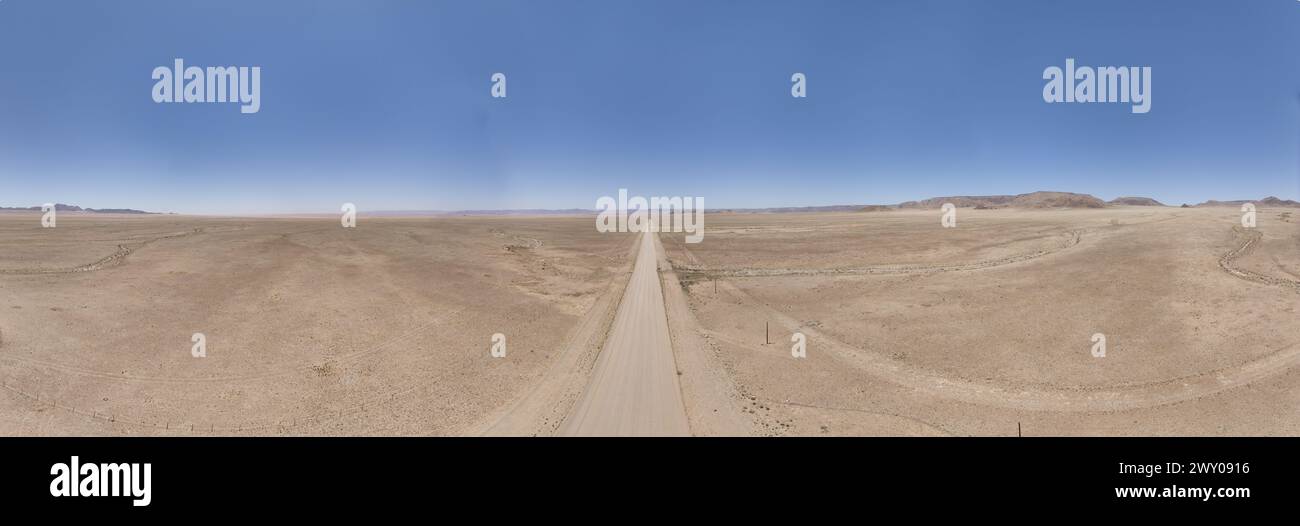 Photo de drone panoramique de route de gravier solitaire à travers le désert sur le bord du parc national Namib-Naukluft en Namibie pendant la journée Banque D'Images