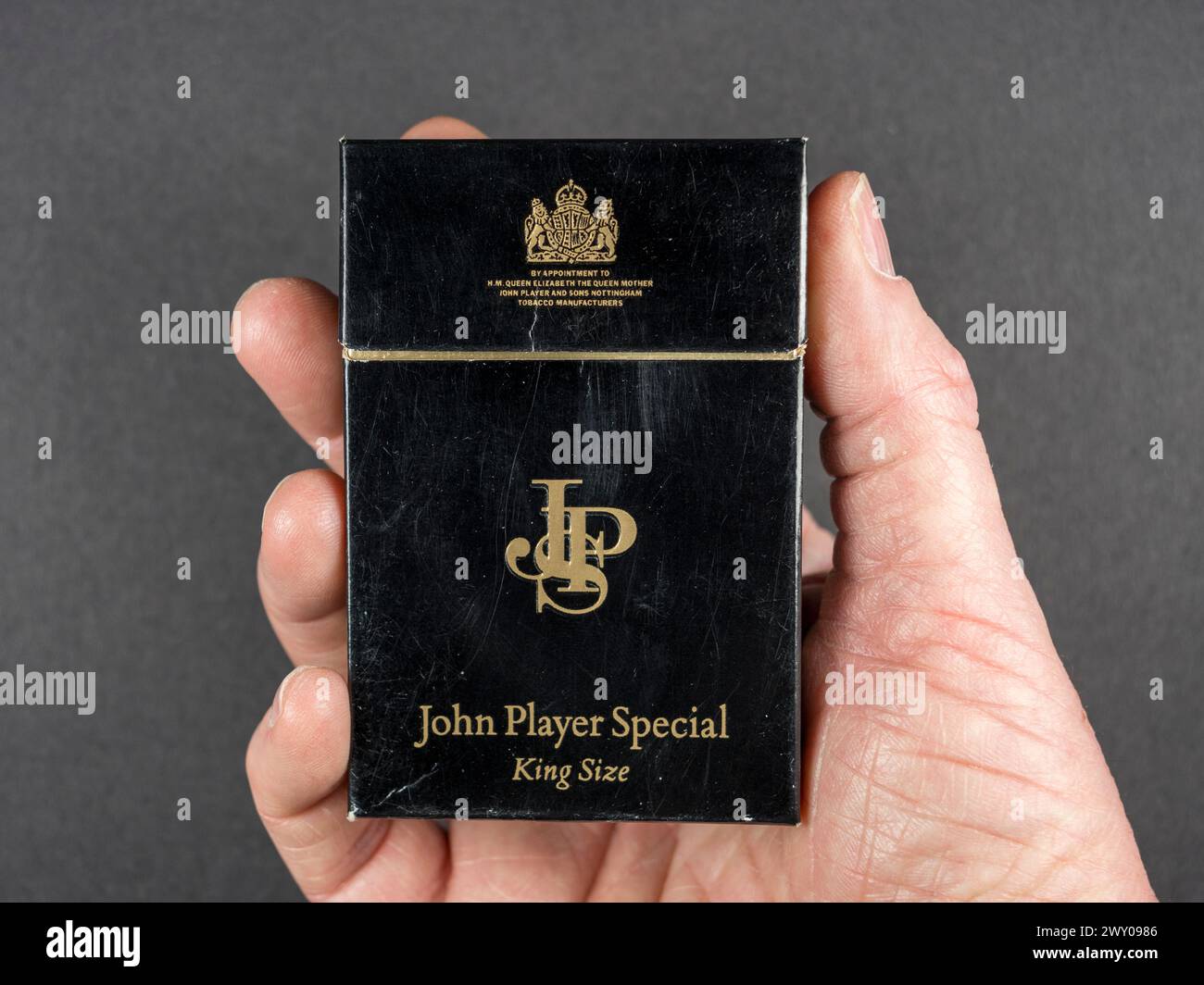 Homme tenant un paquet vide original de 20 cigarettes John Player Special (JPS) d'environ 1990. Banque D'Images