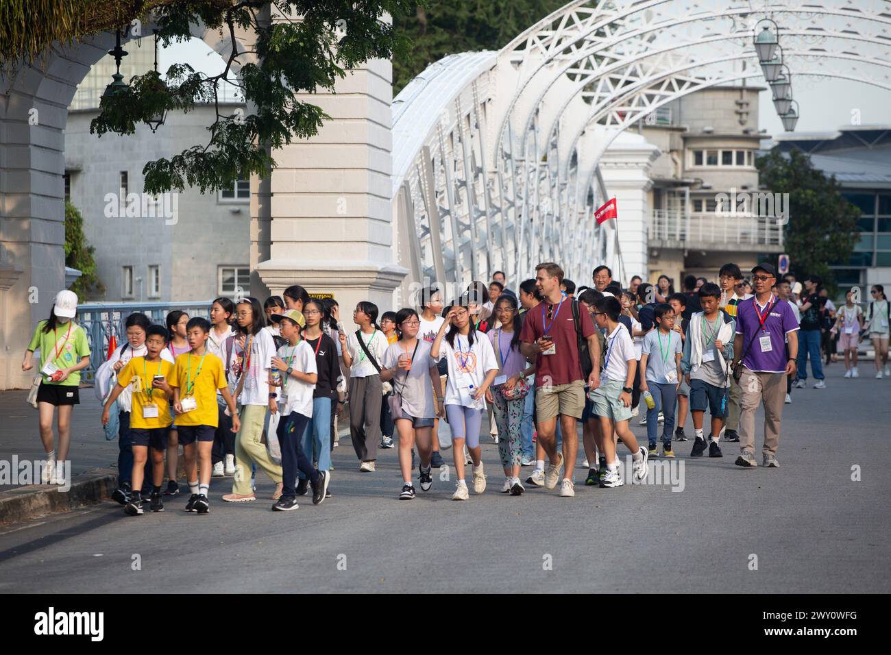Étudiants chinois asiatiques marchant sur la route avec un professeur, heureux, excités, profiter du voyage touristique, marcher vers la prochaine destination. Singapour. Banque D'Images