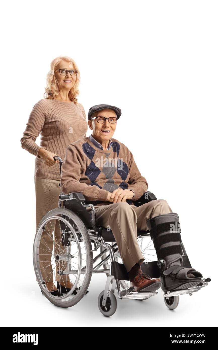 Homme avec une attelle de jambe assis dans un fauteuil roulant avec une femme derrière lui isolé sur fond blanc Banque D'Images