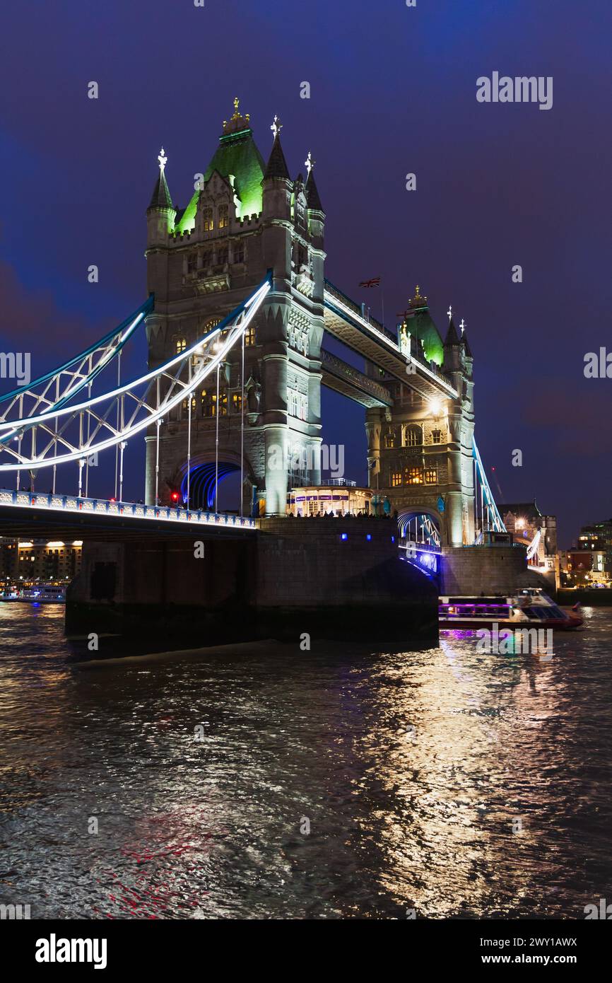 Londres, Royaume-Uni - 04 novembre 2017 : photo verticale de Tower Bridge la nuit avec des reflets colorés dans l'eau de la Tamise Banque D'Images