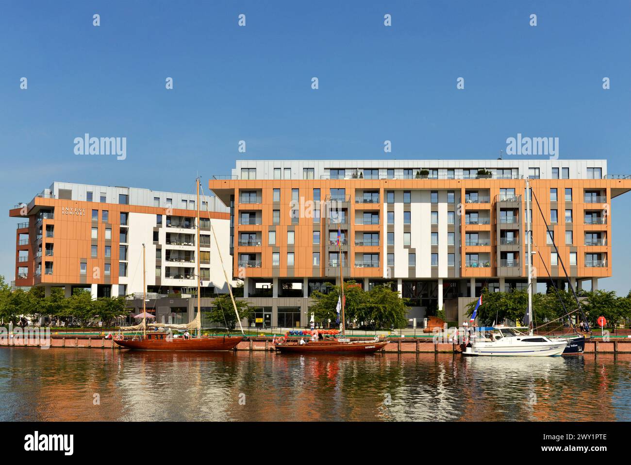 Voiliers amarrés et yachts dans la rivière Motlawa par des immeubles d'appartements de vacances modernes à louer par Invest Komfort dans la vieille ville de Gdansk Pologne, Europe Banque D'Images