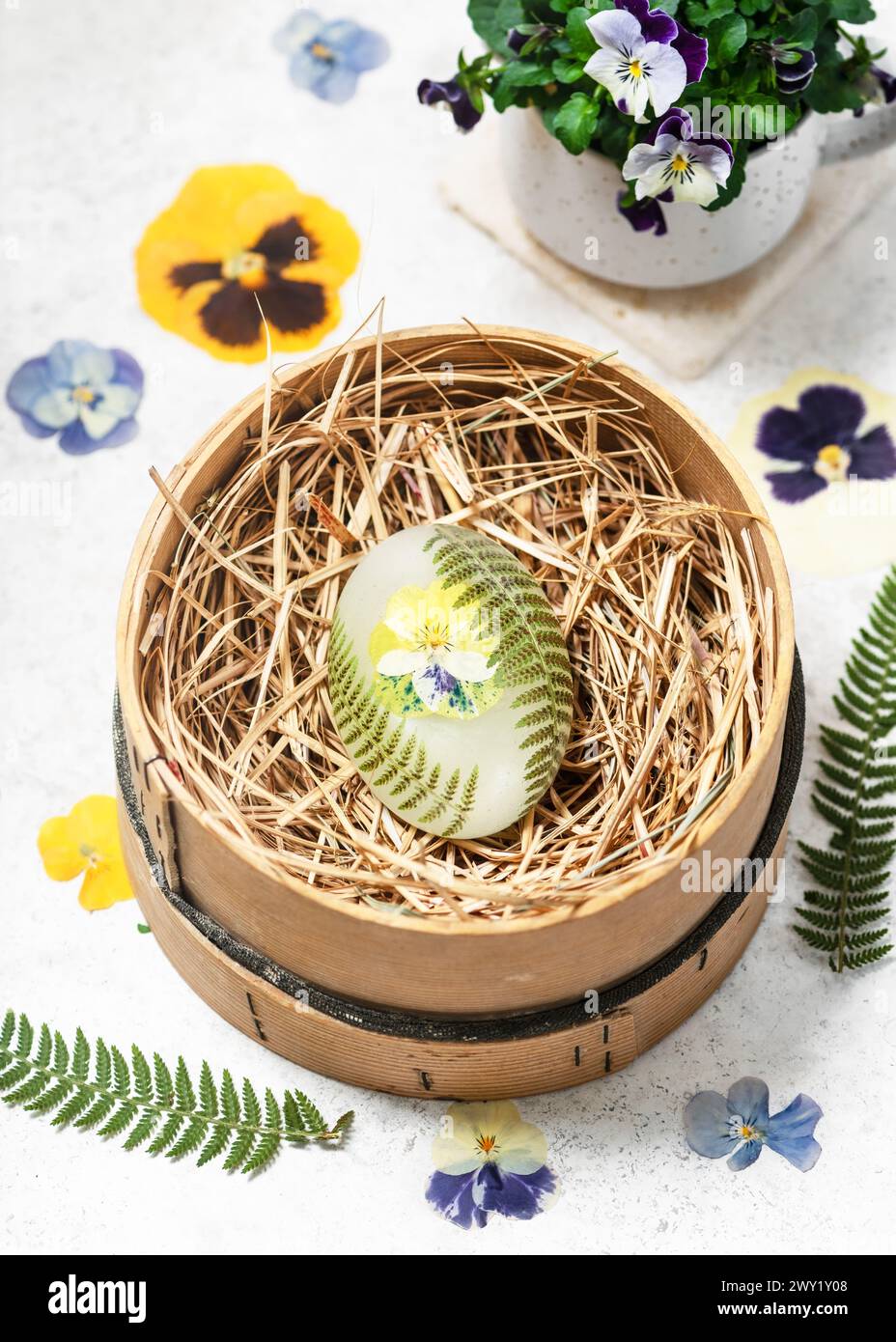 Savon organique fait à la main avec des fleurs pressées, feuilles de fougère dans une boîte en bois avec de la paille. Concept DIY avec enfants. Petit cadeau pour Pâques, Saint Valentin Banque D'Images