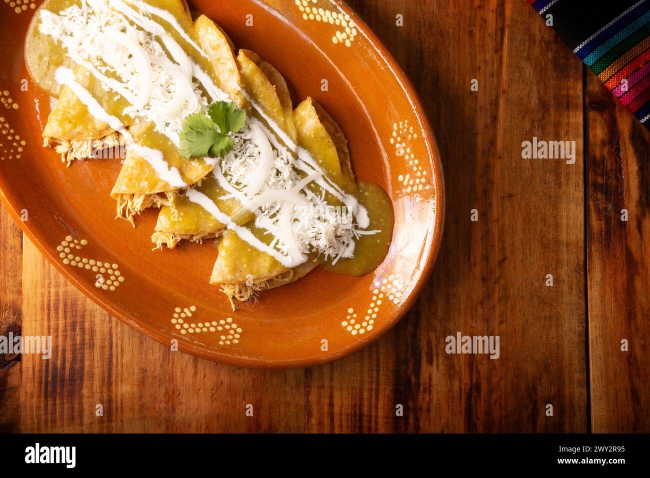 Enchiladas vertes. Plat mexicain typique fait avec une tortilla de maïs pliée ou roulée remplie de poulet râpé et recouverte de sauce verte épicée, cre Banque D'Images