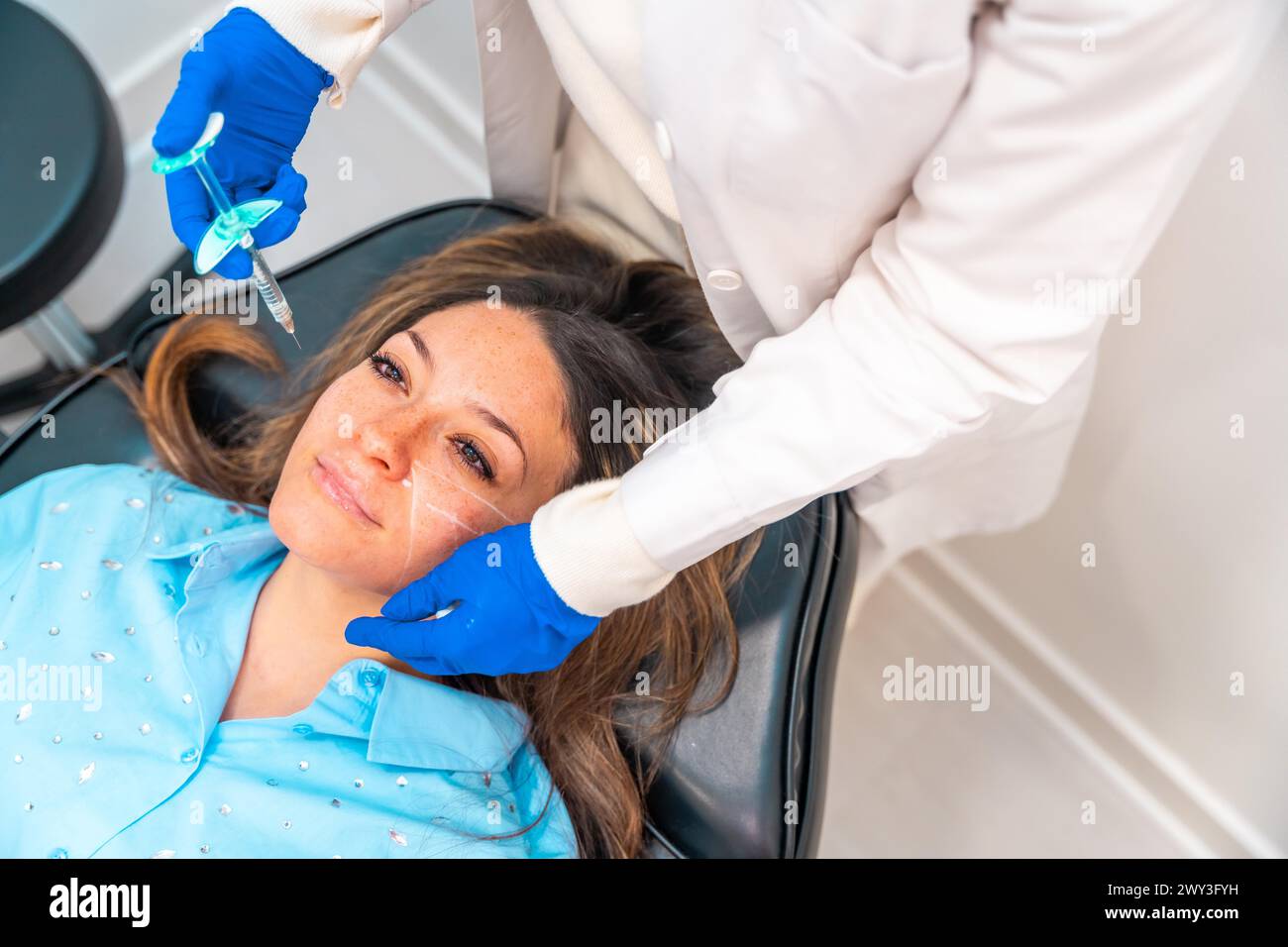 Femme recevant une injection d'acide hyaluronique au visage dans une clinique de beauté Banque D'Images