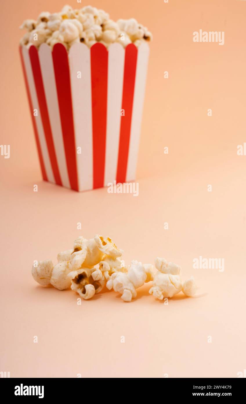 Un seau de pop-corn rayé sur un fond bronzé. Banque D'Images