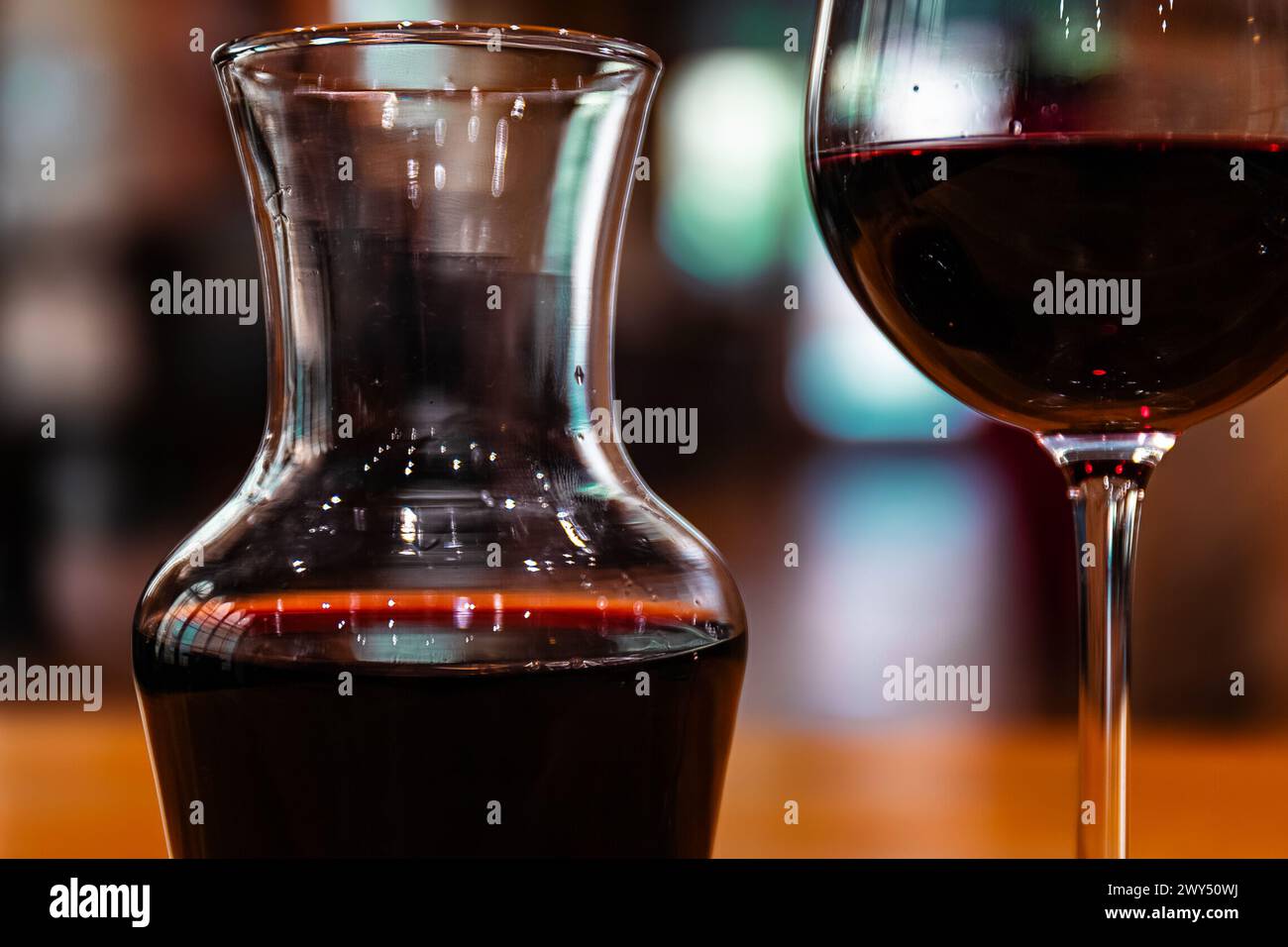Cruche en verre et verre à vin avec du vin rouge sur fond sombre. Banque D'Images