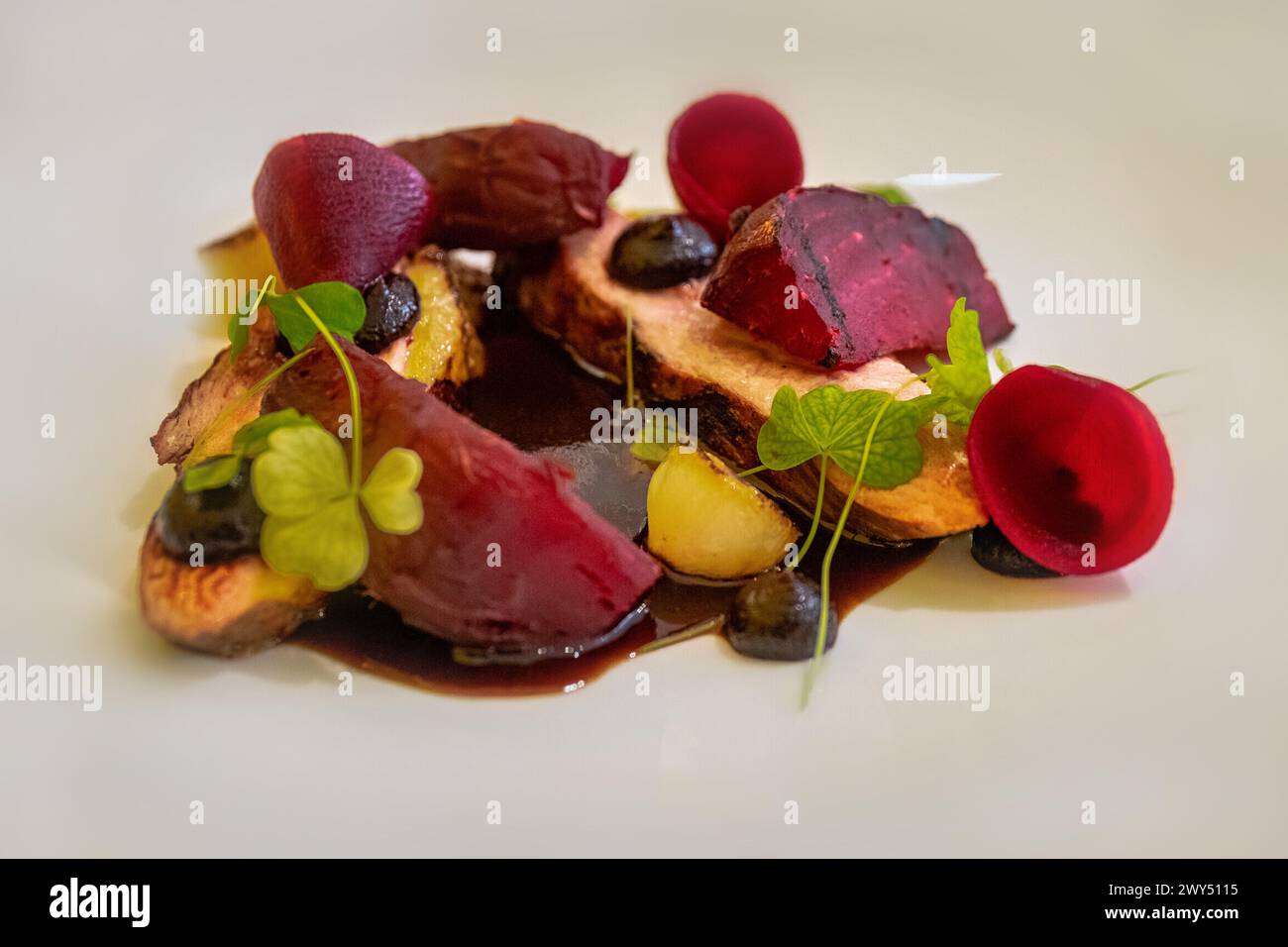 Plat de betteraves et légumes de pommes de terre avec sauce et feuilles de trèfle vert. Un plat gastronomique pour végétaliens. Cuisine française. Banque D'Images