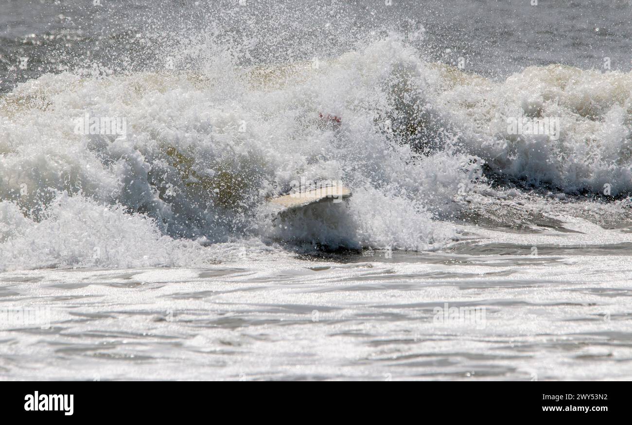 Tout ce que vous pouvez voir après un surfeur wips Out est sa planche de surf dans l'eau agitée après que le surfeur s'efface et tombe. Banque D'Images
