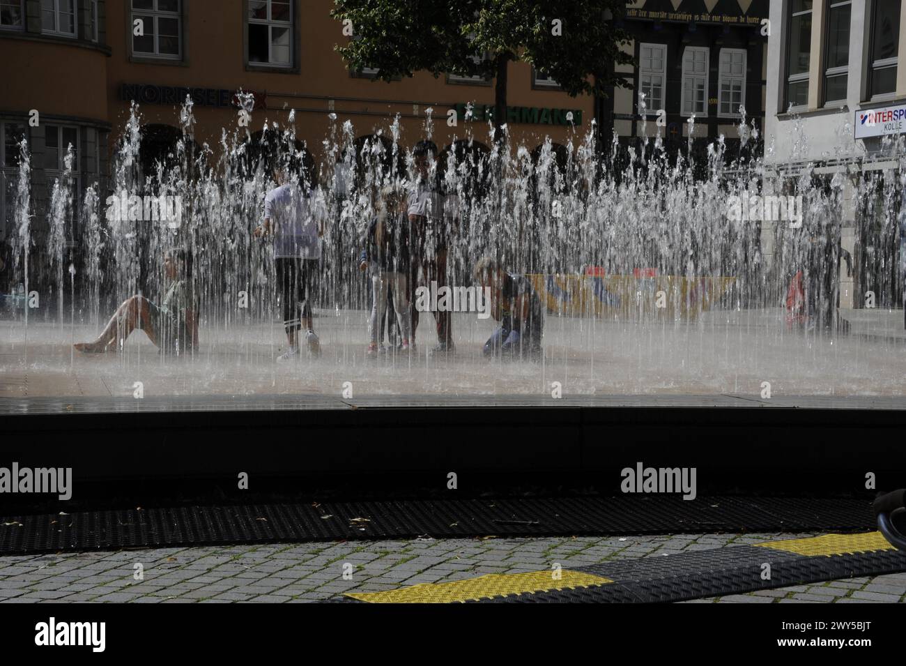Les enfants jouent dans une fontaine d'eau dynamique à Hameln, en Allemagne Banque D'Images