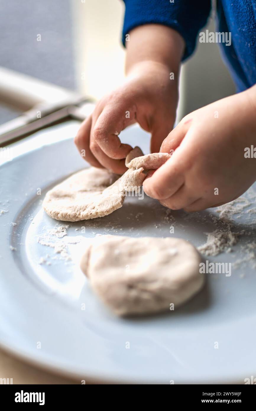 Enfant ayant une pâte à modeler amusante, activité authentique pour le développement de la motricité fine Banque D'Images