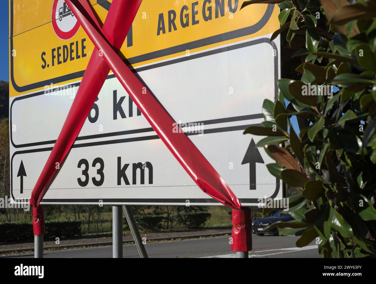 Panneau de distance routière, direction et destination avec bande rouge pendant les travaux, Italie Banque D'Images