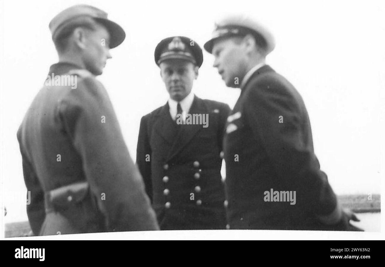 Un officier allemand et un officier de la marine danoise discutent de la reddition officielle de l'île de Middelgrunden, observée par l'officier de la marine britannique, le lieutenant C. Fisher, lors de la remise des îles fortifiées danoises. Banque D'Images