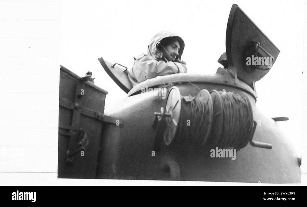 Le lieutenant D.P. Draycott du British Armoured corps dirige le soutien à la 51st Highland Division avançant vers la Maas, portant une protection hivernale contre les vents violents à travers le terrain plat, dans le cadre des opérations de l'armée britannique, du 21st Army Group. Banque D'Images