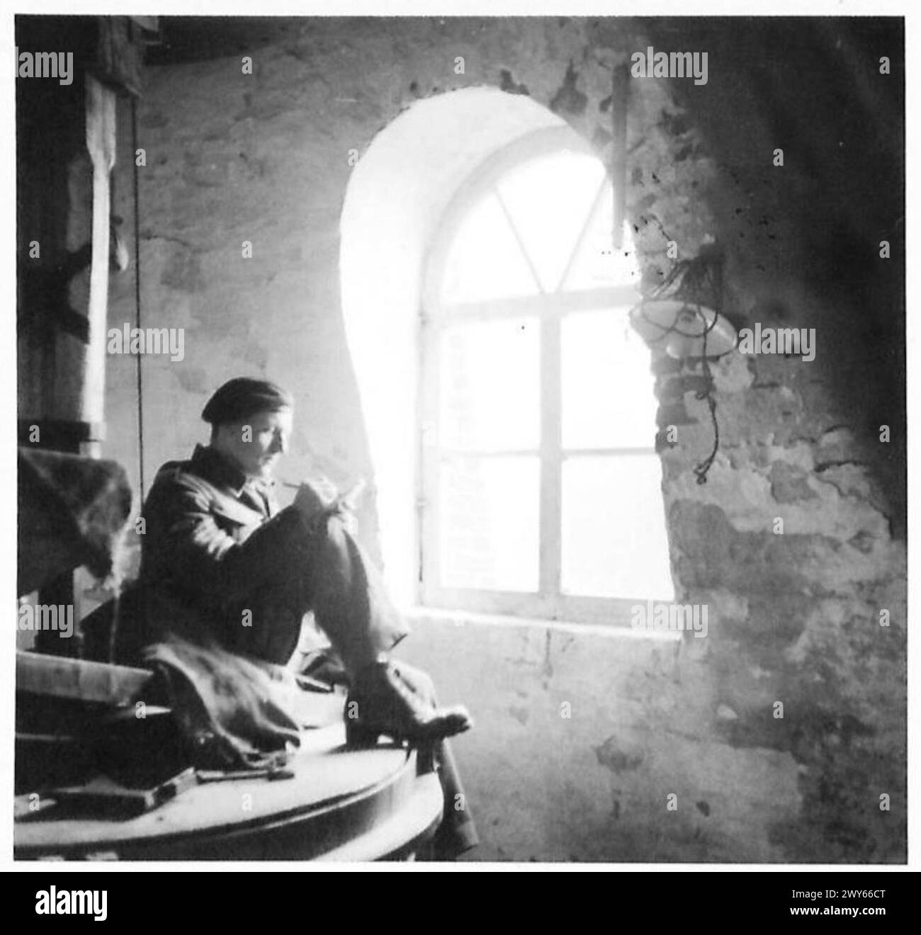 Le caporal William Walls de Chester écrit une lettre chez lui assis sur une meule à l'intérieur d'un moulin à vent hollandais, illustrant la vie quotidienne du personnel de l'armée britannique du 21e groupe d'armées. Banque D'Images