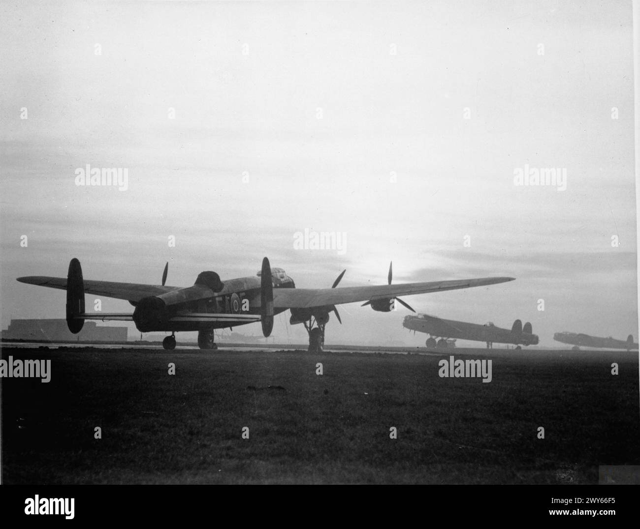 COMMANDEMENT DES BOMBARDIERS DE LA ROYAL AIR FORCE, 1942-1945. - Les Avro Lancasters attendent leurs équipages dans leurs dispersions au coucher du soleil, avant de décoller de Scampton, Lincolnshire pour un bombardement. L'avion le plus proche est un Mark I, R5751 'EA-E', du No. 49 Squadron RAF, normalement basé à Fiskerton, également dans le Lincolnshire. , Royal Air Force, Royal Air Force Regiment, Sqdn, 49 Banque D'Images