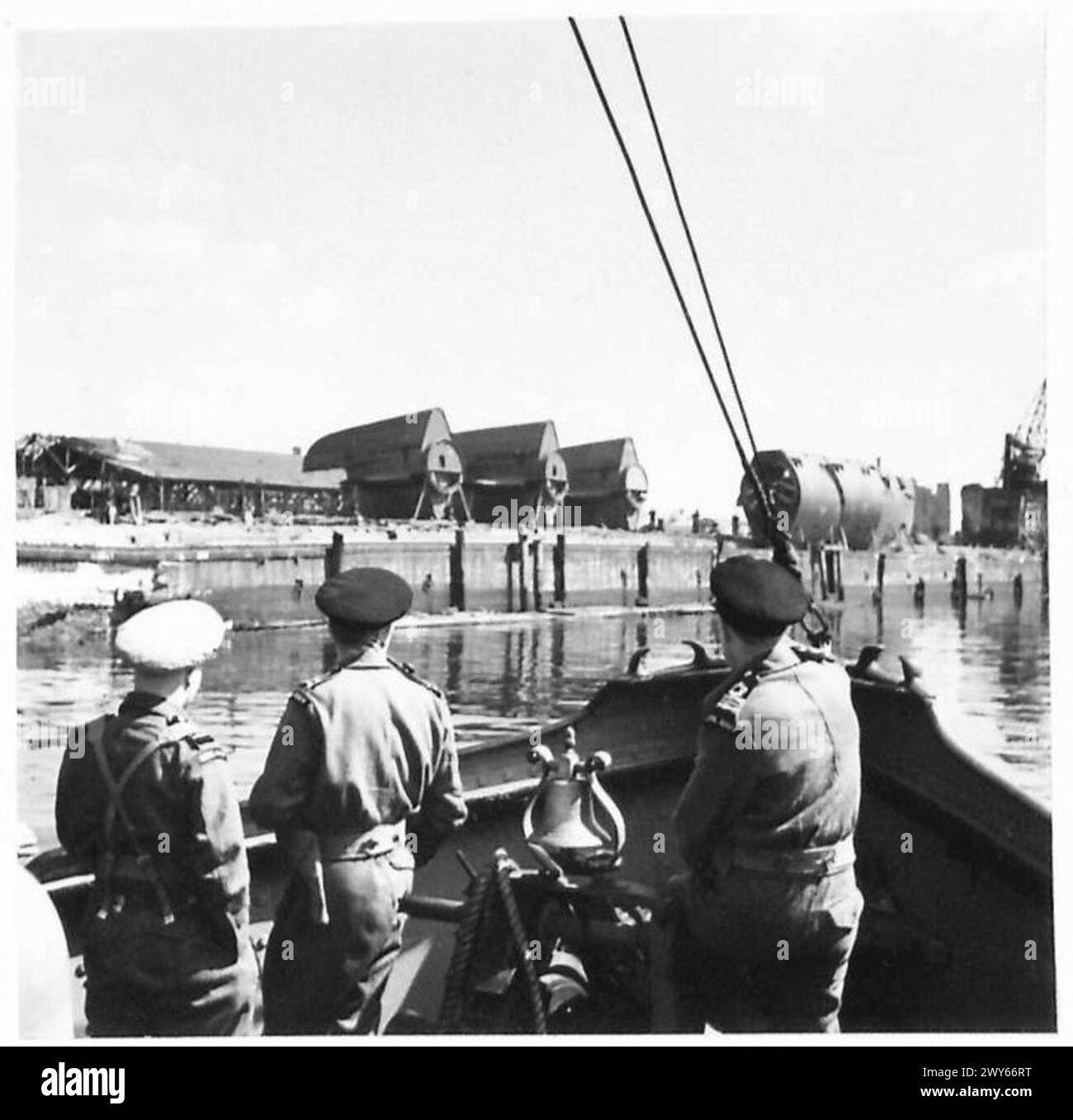 Le personnel de la Royal Naval se déplace le long de la rivière au port de Hambourg, avec le parc sous-marin visible en arrière-plan, pendant les opérations de l'armée britannique du 21e groupe d'armées. Banque D'Images