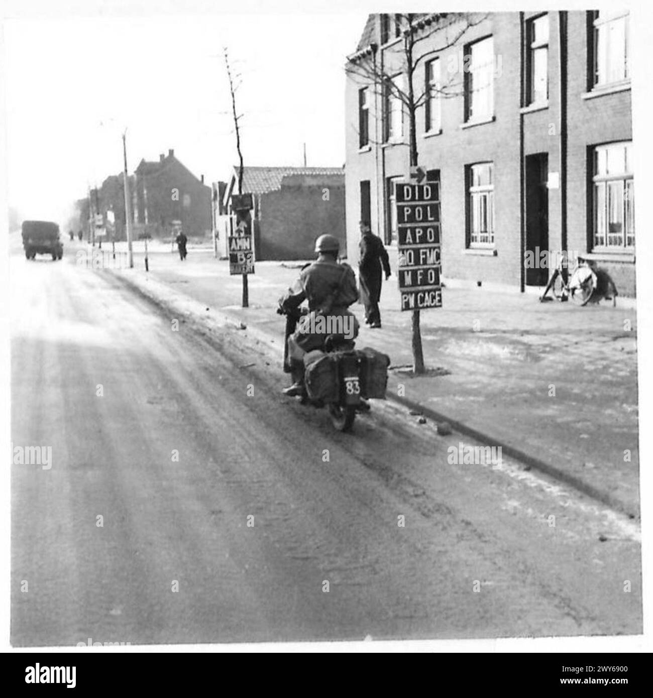 Le l/Cpl F. Holland du corps Stein de la police militaire vérifie les panneaux routiers sur une moto pendant les opérations du 21e groupe d'armées britannique. Banque D'Images